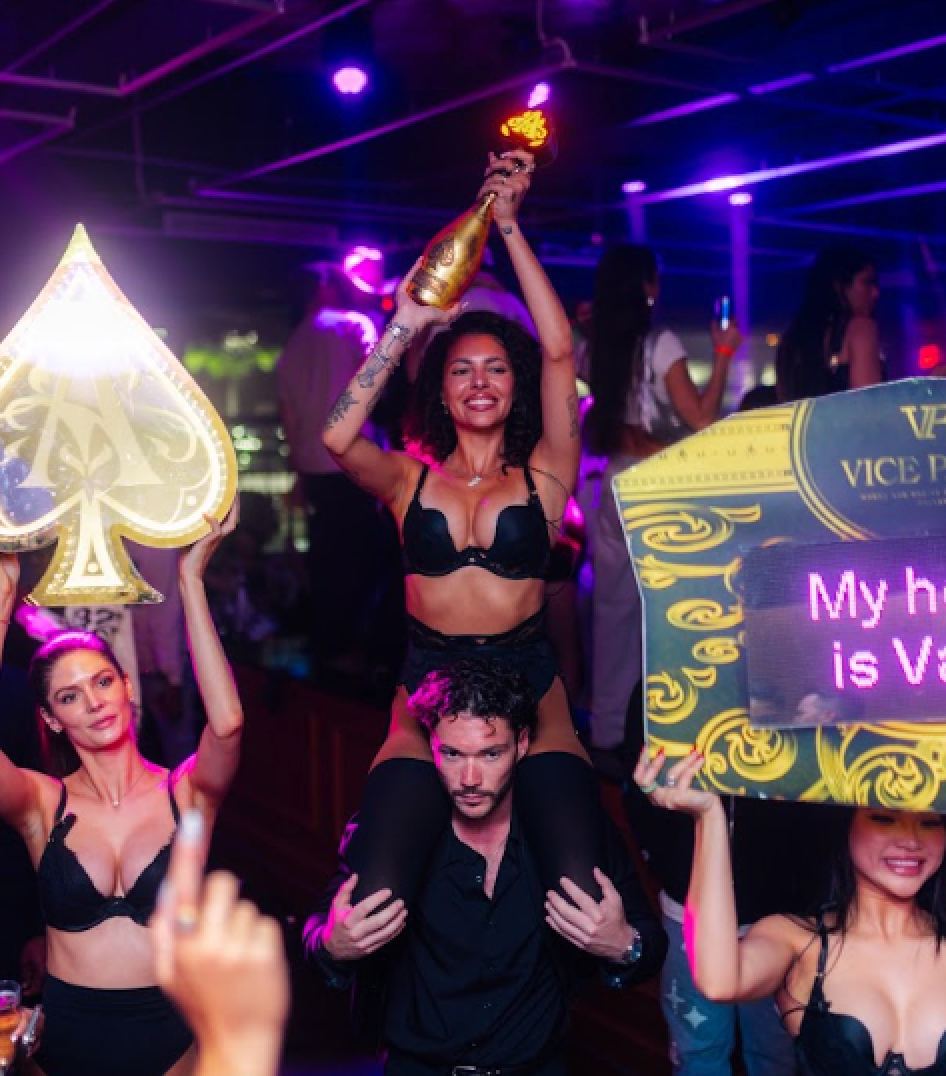 Guests raising an illuminated champagne bottle and a lit Vice Park LED sign on the main floor