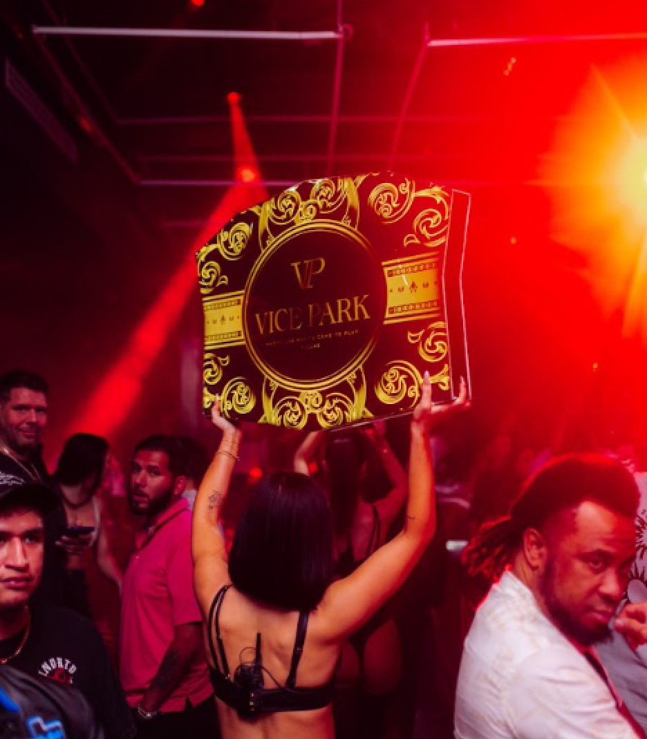 Gilded Vice Park LED bottle-service sign carried through a red-lit crowd